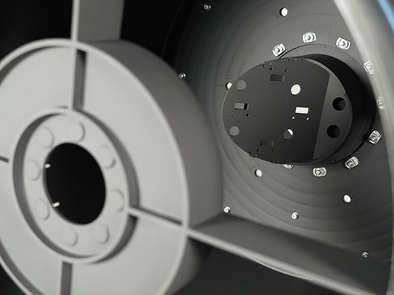 This images looks into the telescope's spider structure where mirrors will be mounted. There is a central raised and angled surface with machined cutouts. It is surrounded by metallic inserts and additional cutouts.