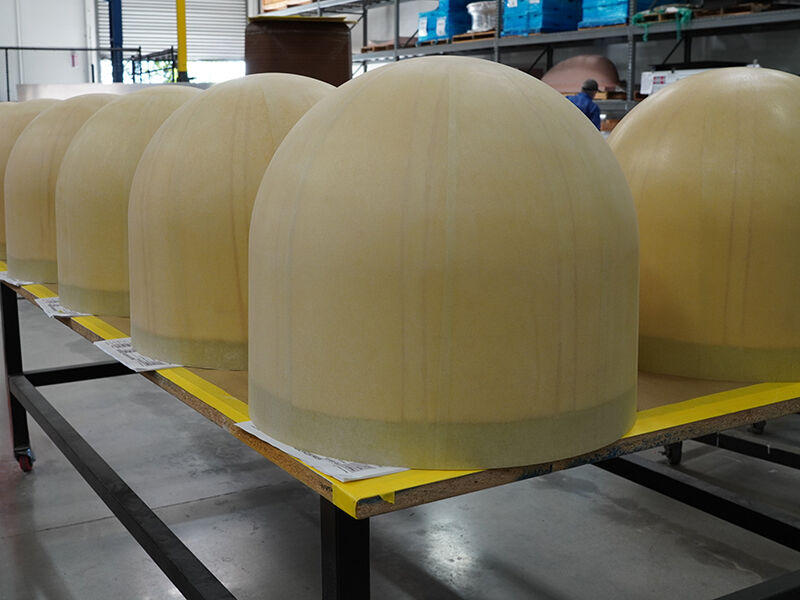 Radomes waiting for coating A series of radomes sitting on a table in a warehouse before being taken into an area for coating.