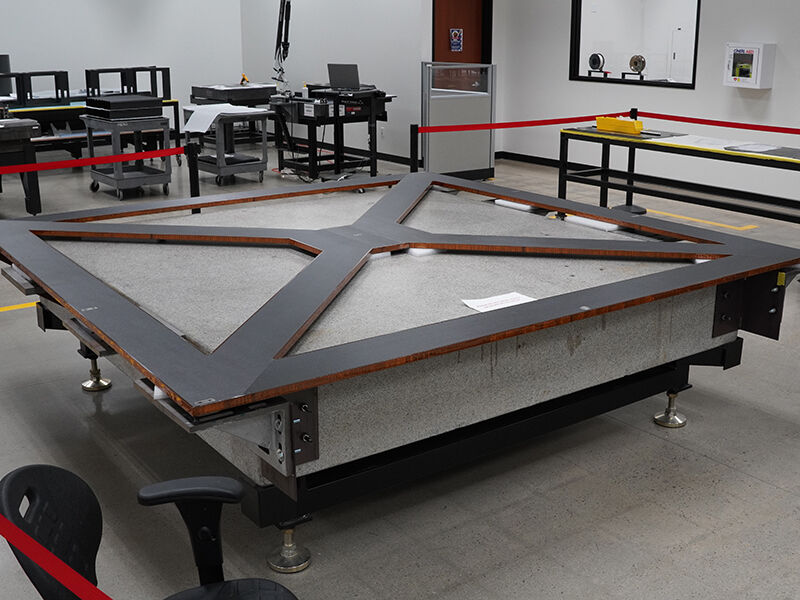 A single NASA PASS bond fixture panel on a granite surface in a manufacturing space