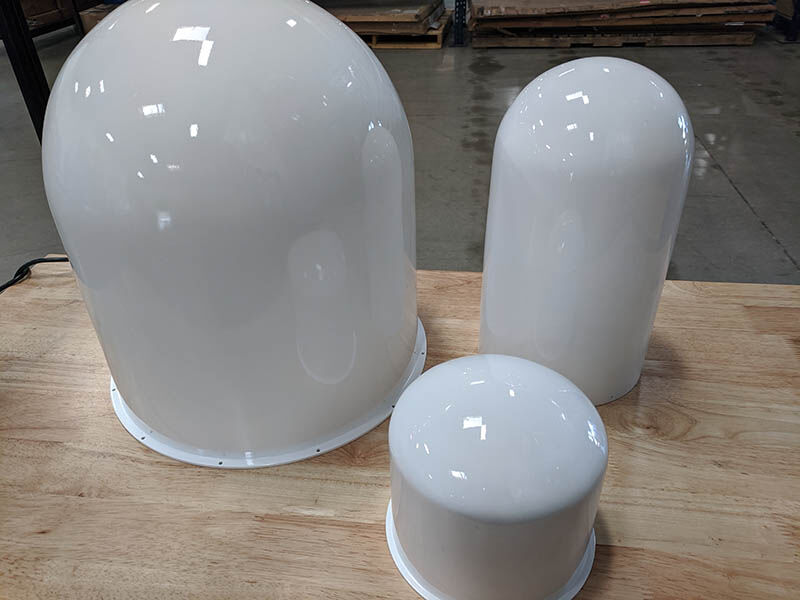 Radome assortment Three white radomes of various sizes on a wood work surface in a warehouse